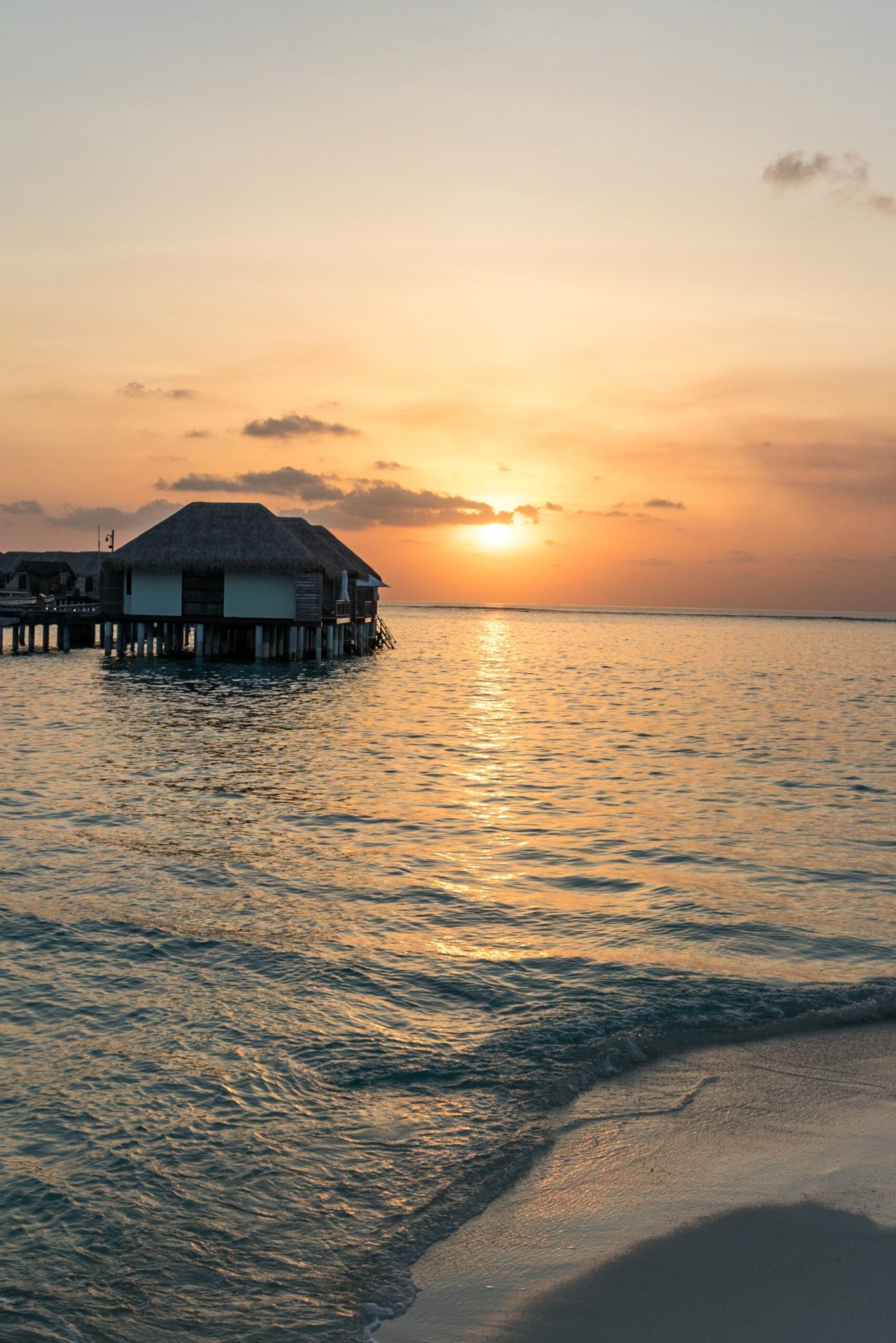 View of the overwater bungalows at sunset in The Maldives